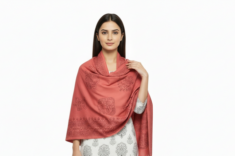 Woman wearing a coral pink scarf with intricate patterns on a white background