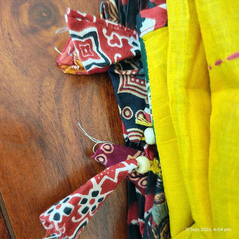 Close-up of hand mirror-work applique and Ajrakh patchwork border on mustard dupatta